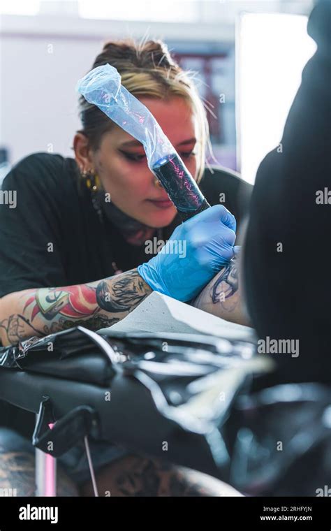 Focused Female Tattoo Artist Drawing A Tattoo On Her Client Leg Tattoo Focused Female Tattoo Artist Drawing A Tattoo On Her Client Leg Tattoo