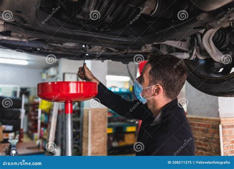 Mechanic Changing The Oil Of The Car Concept Automobile Mechanics Mechanic Changing The Oil Of The Car Concept Automobile Mechanics